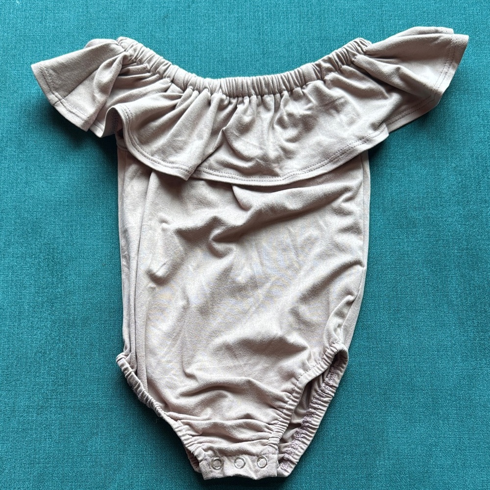 Baileys Blossom’s Off-Shoulder Baby Onesie in Light Dusty Pink